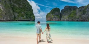 Coppia su spiaggia tropicale di Maya Bay con acqua cristallina
