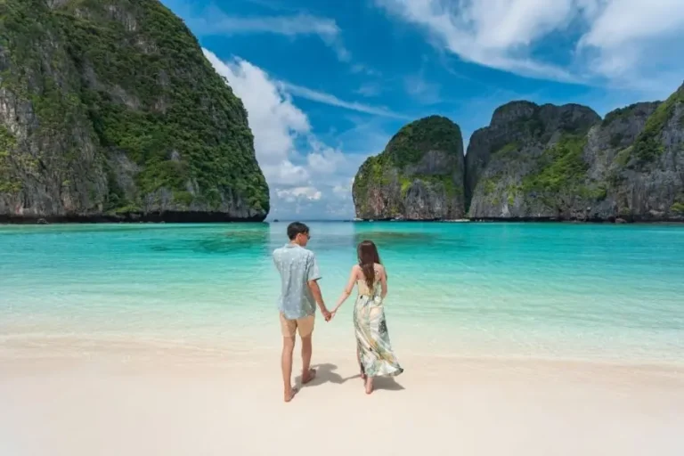 Coppia su spiaggia tropicale di Maya Bay con acqua cristallina