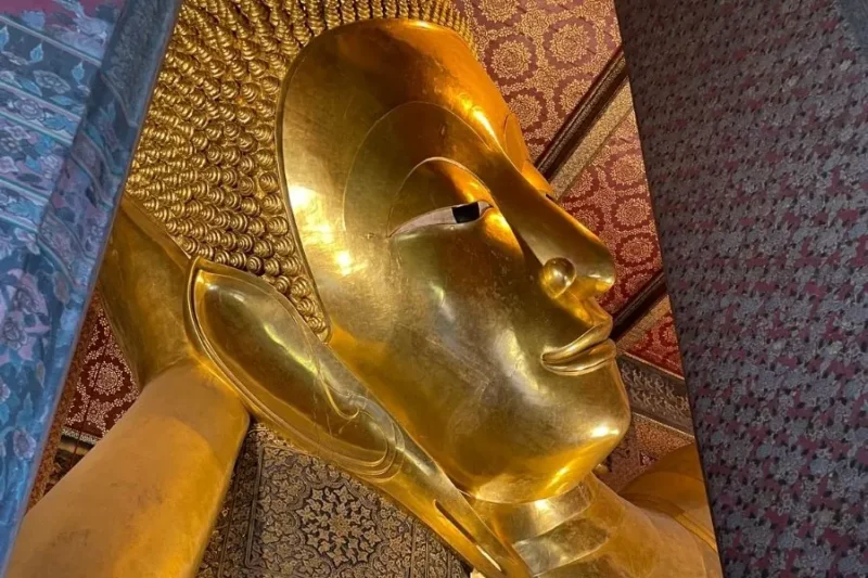Dettaglio statua dorata del Buddha sdraiato a Wat Pho, Bangkok