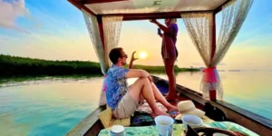 Coppia su una barca ammirando il tramonto con tè e dolci
