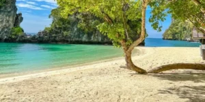 Spiaggia tropicale Koh Hong con sabbia bianca e mare turchese, alberi e scogliere verdi