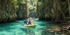 Persone in kayak esplorano acque cristalline di Klong Nam Sai Klong Root tra formazioni rocciose e vegetazione lussureggiante