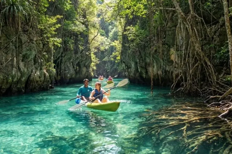 Persone in kayak esplorano acque cristalline di Klong Nam Sai Klong Root tra formazioni rocciose e vegetazione lussureggiante