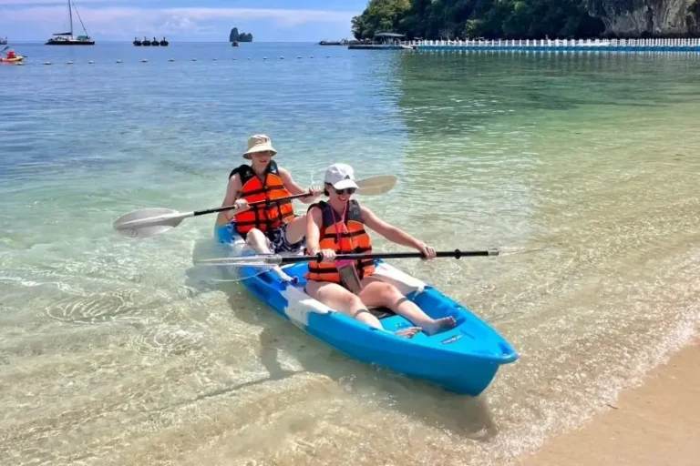 Due persone navigano su un kayak blu in una spiaggia tropicale a Koh Hong