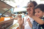 Madre e figlio felici salutano in un mercato galleggiante in Thailandia
