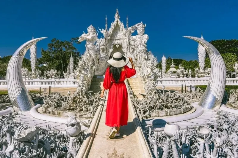 Donna in abito rosso al Tempio Bianco, Wat Rong Khun, Thailandia