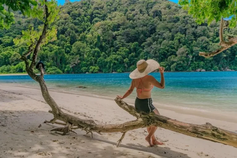 Donna con cappello sulla spiaggia tropicale con mare cristallino in Surin Island