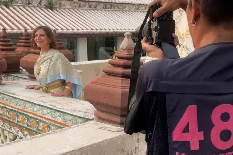Fotografo cattura immagine di donna in abbigliamento tradizionale davanti a tempio