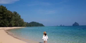 Donna cammina a Koh Kradan, spiaggia tropicale con acque turchesi