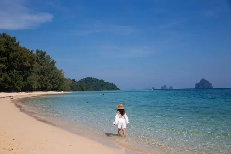 Donna cammina a Koh Kradan, spiaggia tropicale con acque turchesi