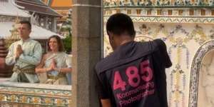 Turisti posano in abiti tradizionali tailandesi per una foto a un tempio