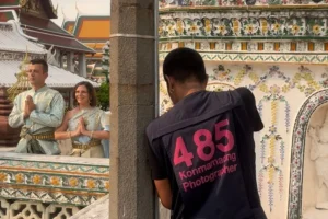 Turisti posano in abiti tradizionali tailandesi per una foto a un tempio