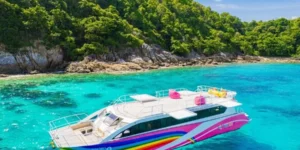 Catamarano colorato in mare cristallino vicino a isola tropicale