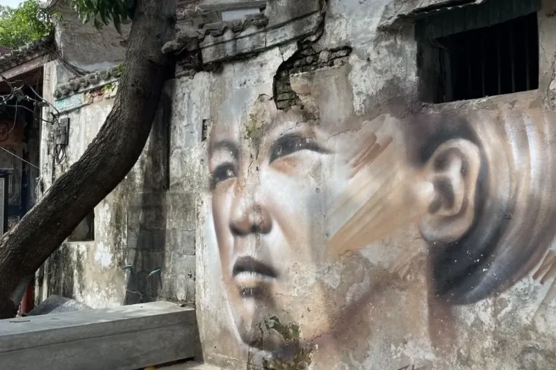 Murale di un volto umano su vecchio edificio a Guangzhou