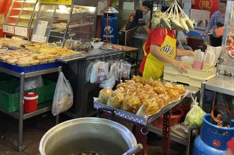 Bancarella di cibo di strada in un mercato asiatico affollato