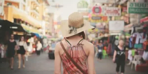 Turista con cappello in strada affollata di Bangkok