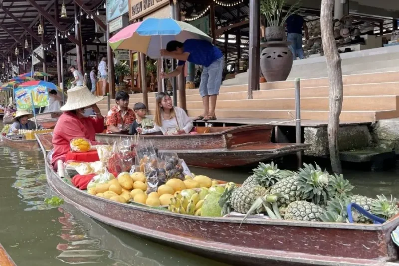 Mercato galleggiante thailandese con barche cariche di frutta esotica Damnoen Saduak Floating Market
