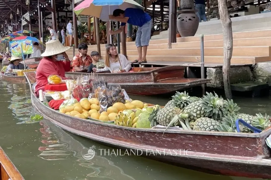 Barca di una venditrice carica di ananas, mango e papaya al mercato galleggiante di Damnoen Saduak, nella provincia di Ratchaburi