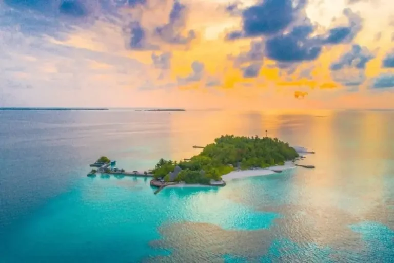 Isola tropicale con tramonto colorato e acque turchesi