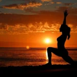 Ragazza pratica yoga sulla spiaggia al tramonto - cosa fare a koh phangan